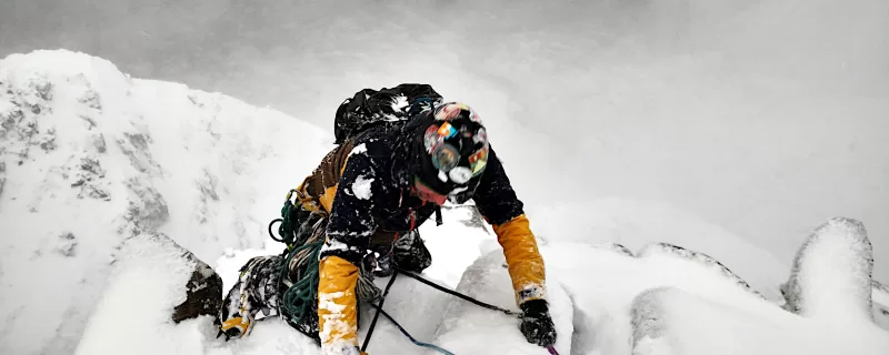 winter climber nearing the top of a route